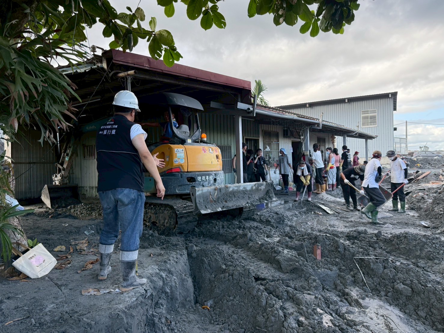 Shovel volunteers and heavy machinery clearing mud together in Guangfu, Hualien